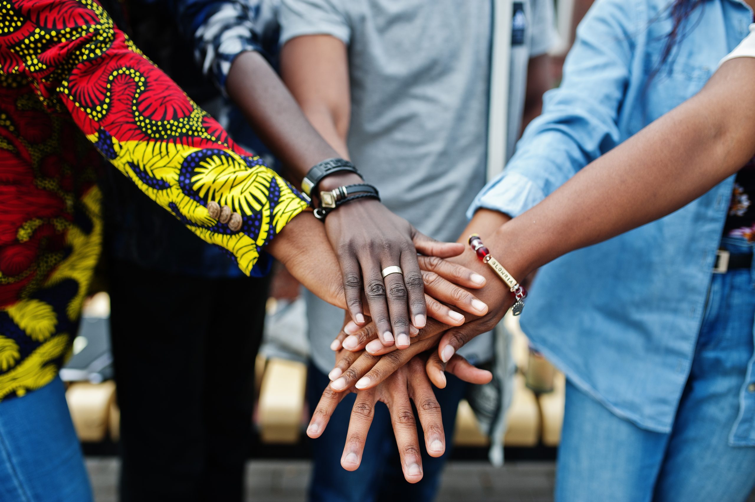 Group of five african college students spending time together on campus at university yard. Black afro friends studying. Education theme. Hands on hands.